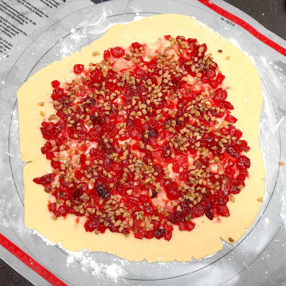 Sprinkling the small chopped walnuts onto the apple-cranberry jam.