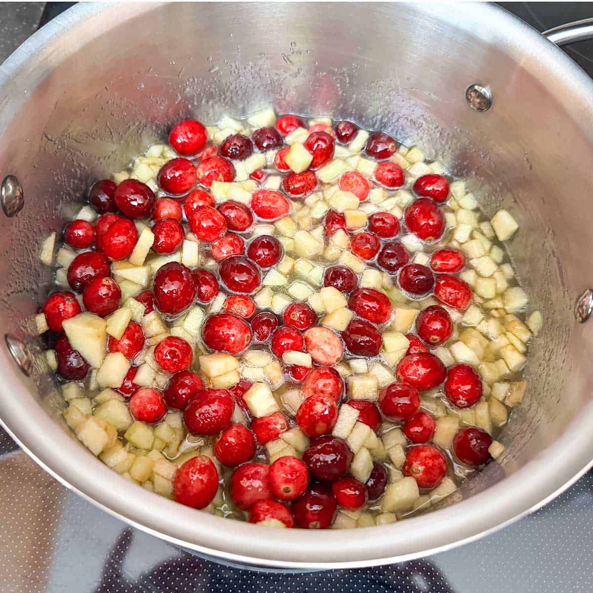 Cutup apple pieces with the fresh cranberries in a 3qt sauce pan.