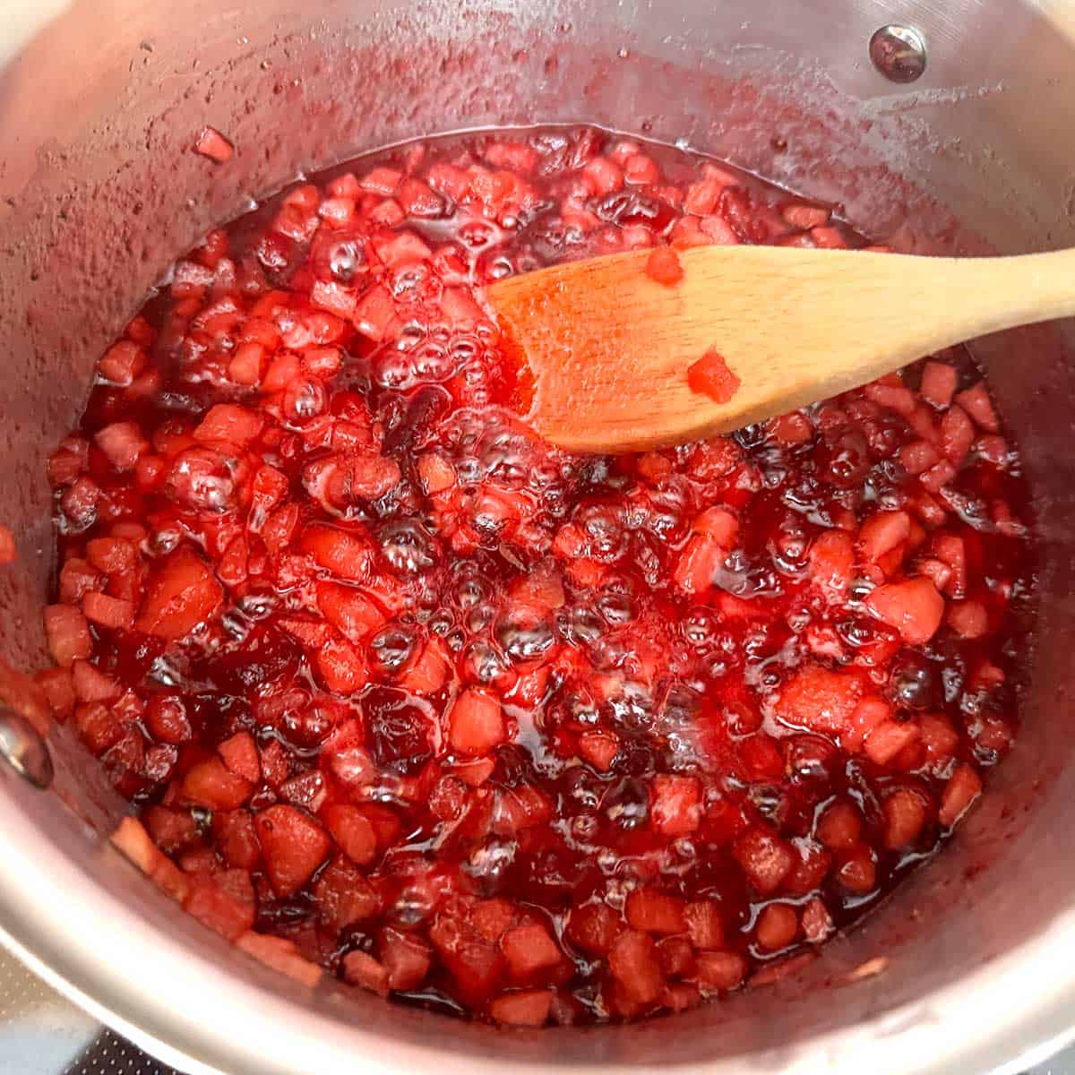 Apple-cranberry jam on a low boil to reduce the liquid.