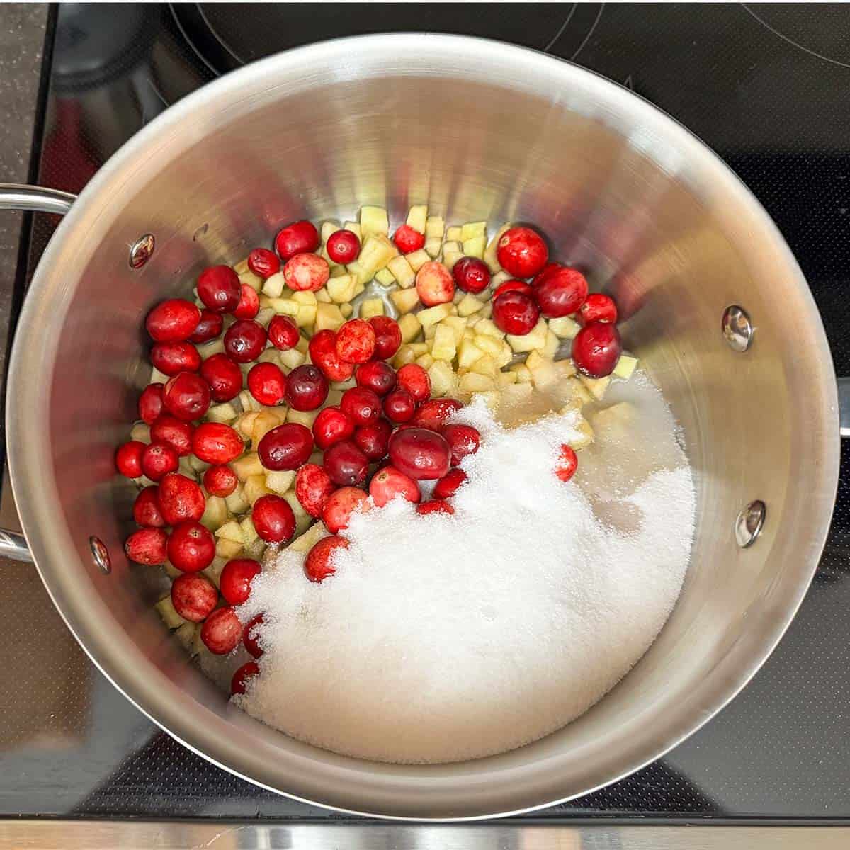 Whole cranberries, diced apples, with sugar and water in a 3qt sauce pan.