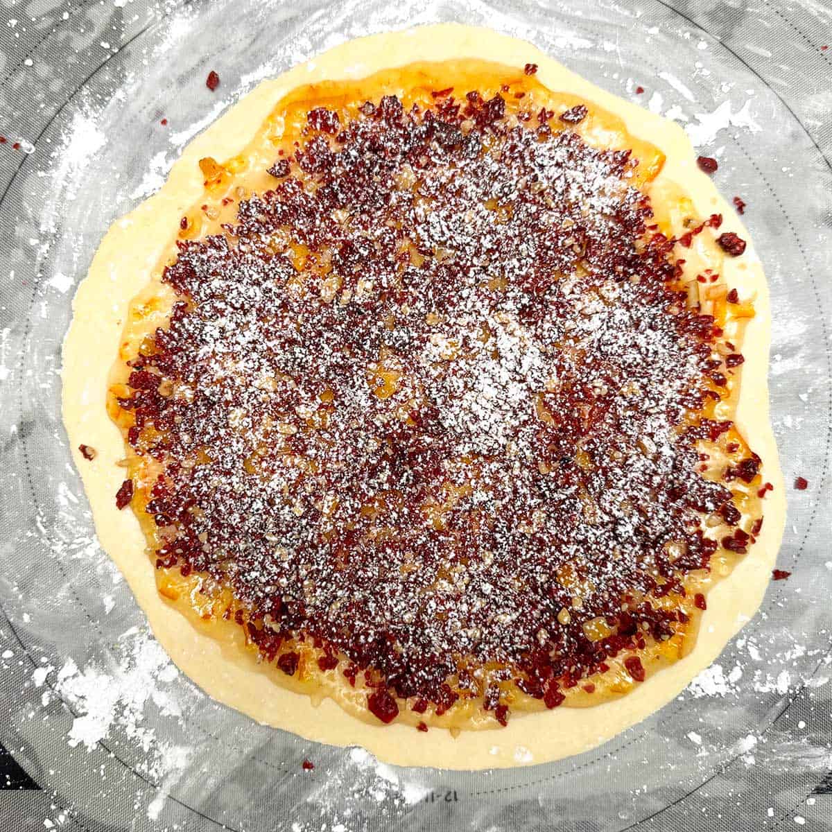 Rolled out in a circle cookie dough with the cranberry filling layered on top of it.