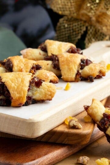 Baked cranberry orange and walnut rugelach on wooden boards.