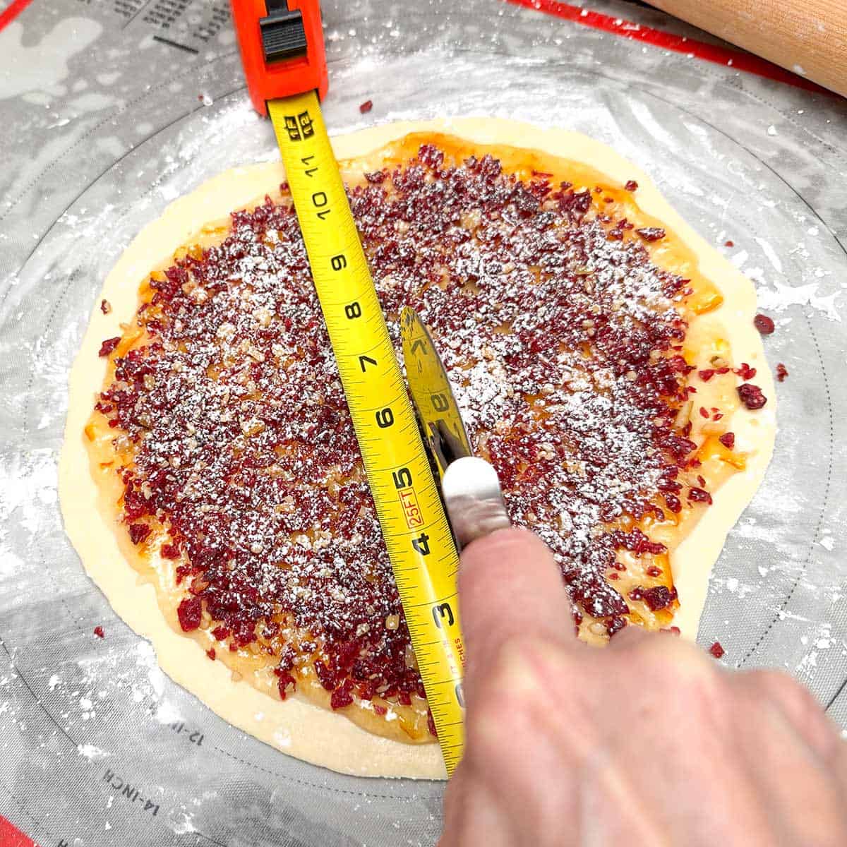 Cutting the cranberry and orange into straight lines so the pie shape can be rolled into a croissant shape.