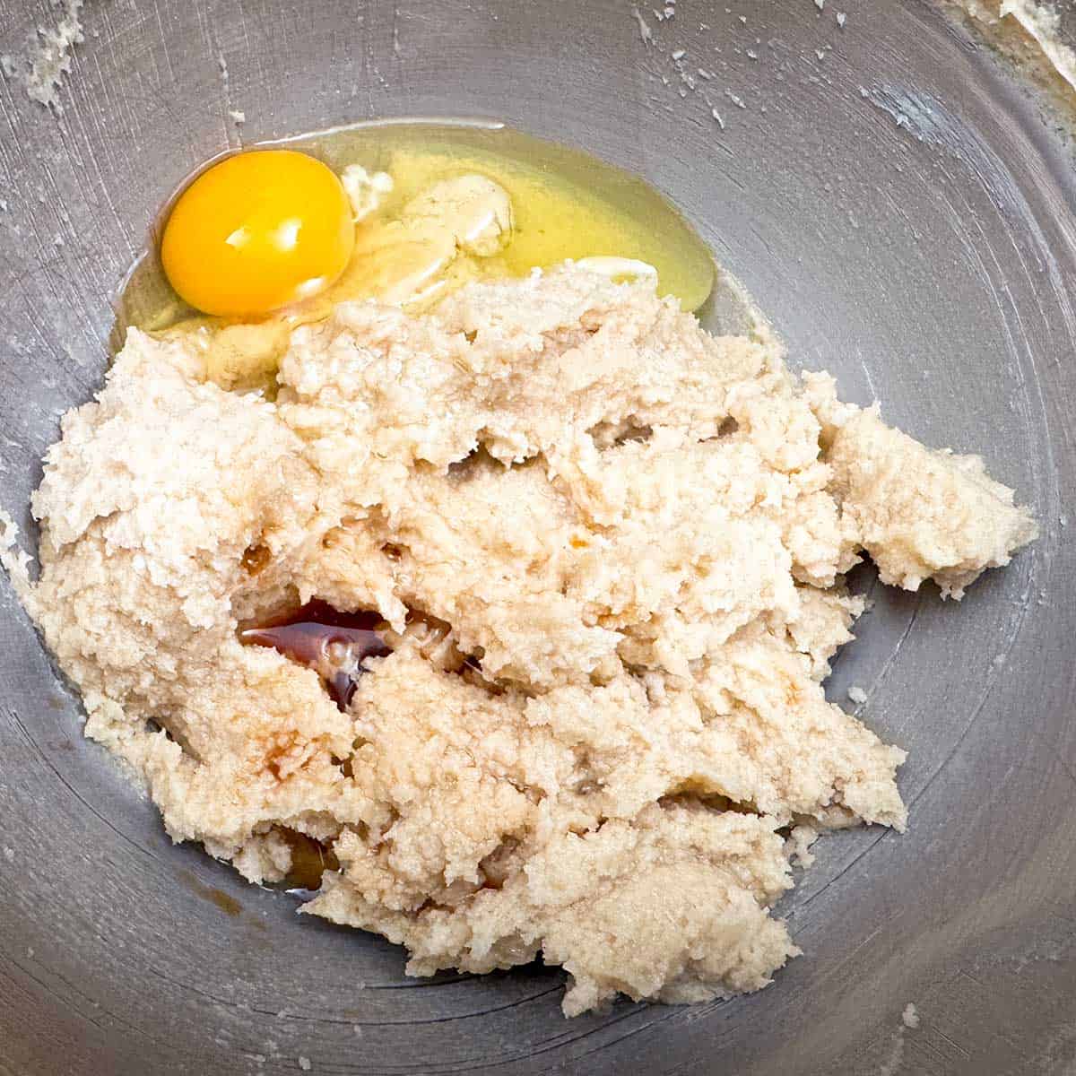 Adding an egg along with both extracts to the butter-sugar mascarpone mixture.