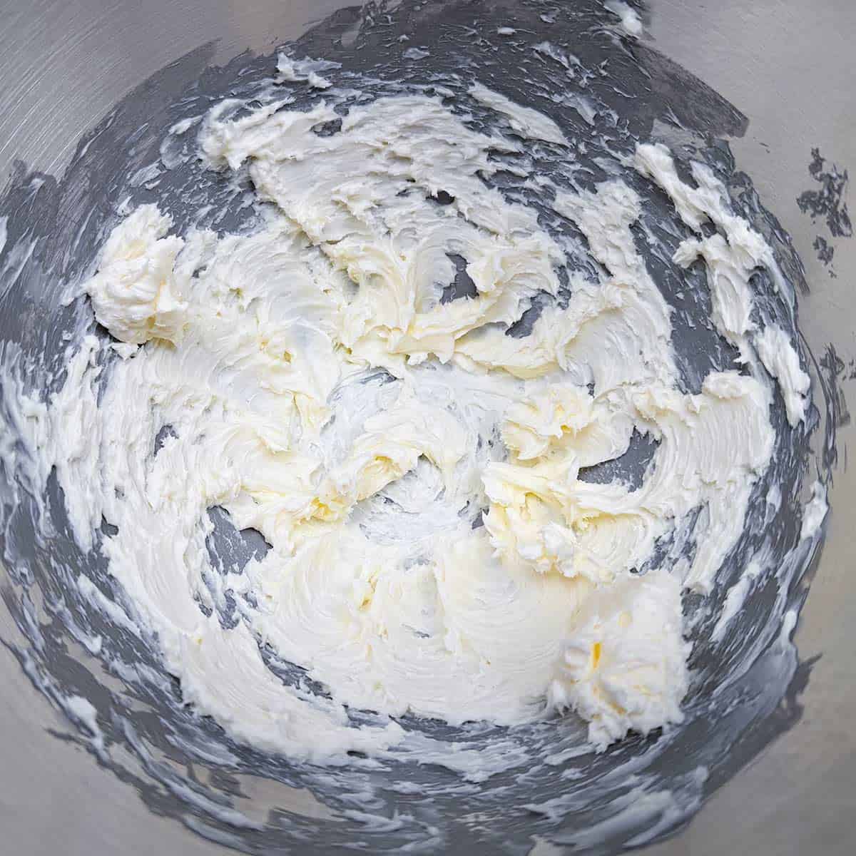 Butter that has been creamed with a mixer. Soft wisps of butter around the mixer bowl.