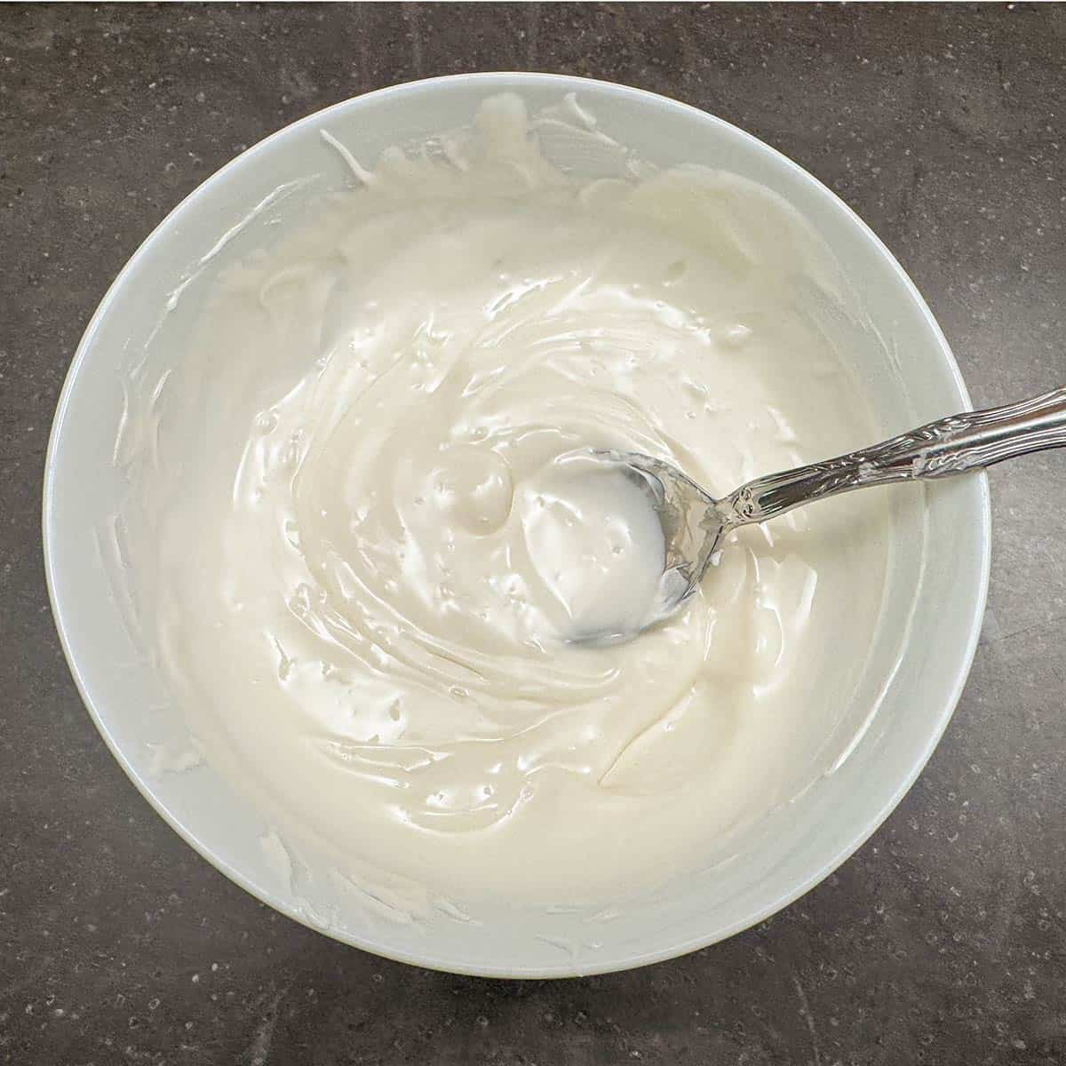 Melted white chocolate ready to be drizzled on top of the baked cookies.