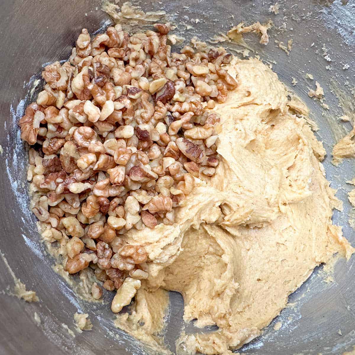 The cookie dough mixed and the walnuts being added.