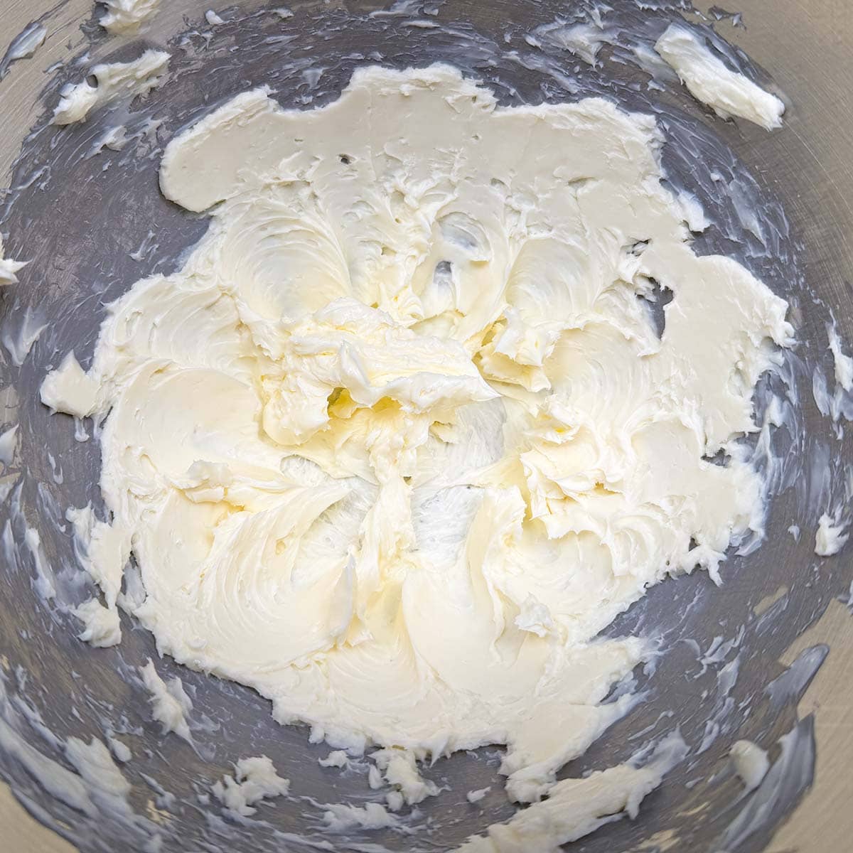 Creamed butter in a mixer bowl and has soft peaks.