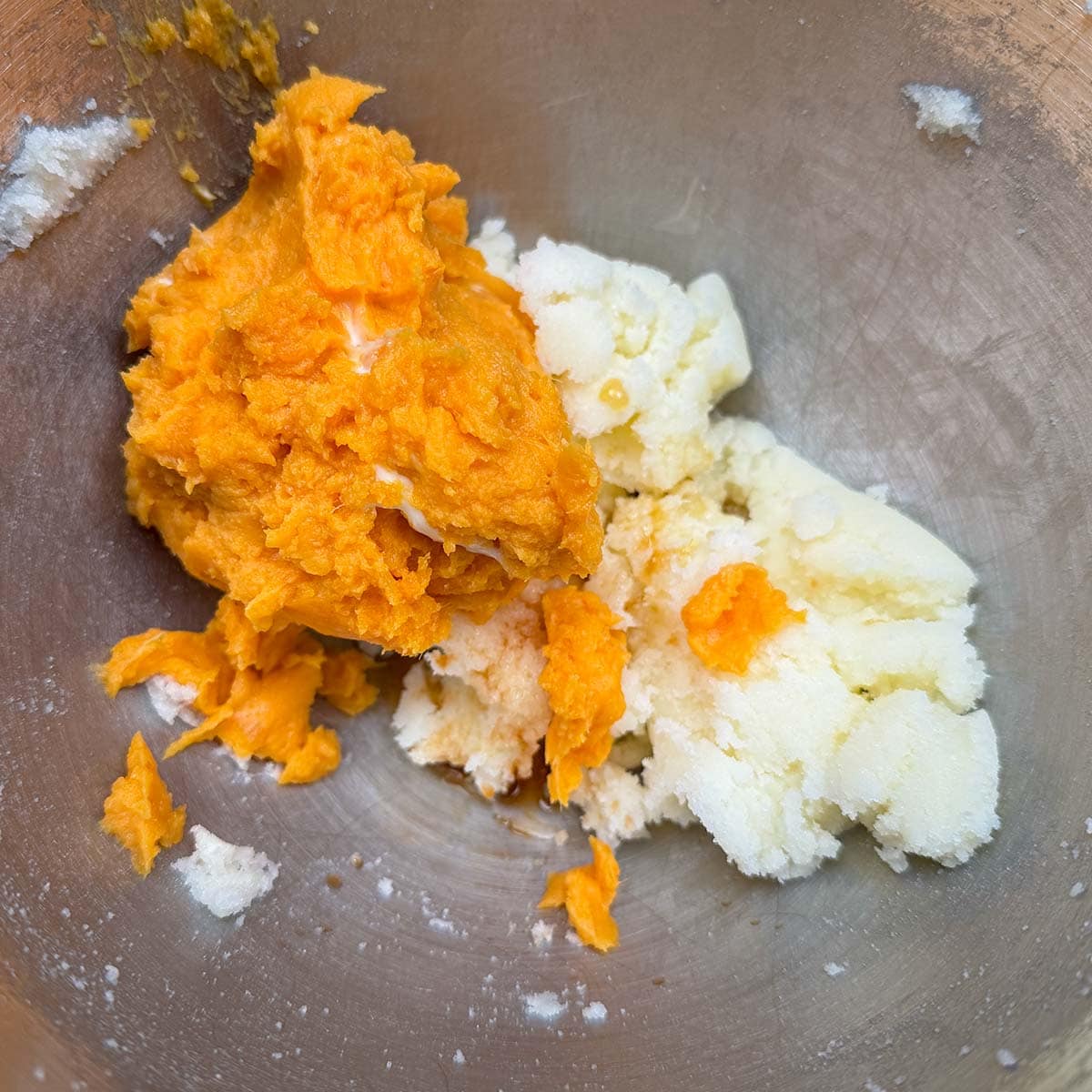 Adding the sweet potato puree to the butter-sugar mixture.