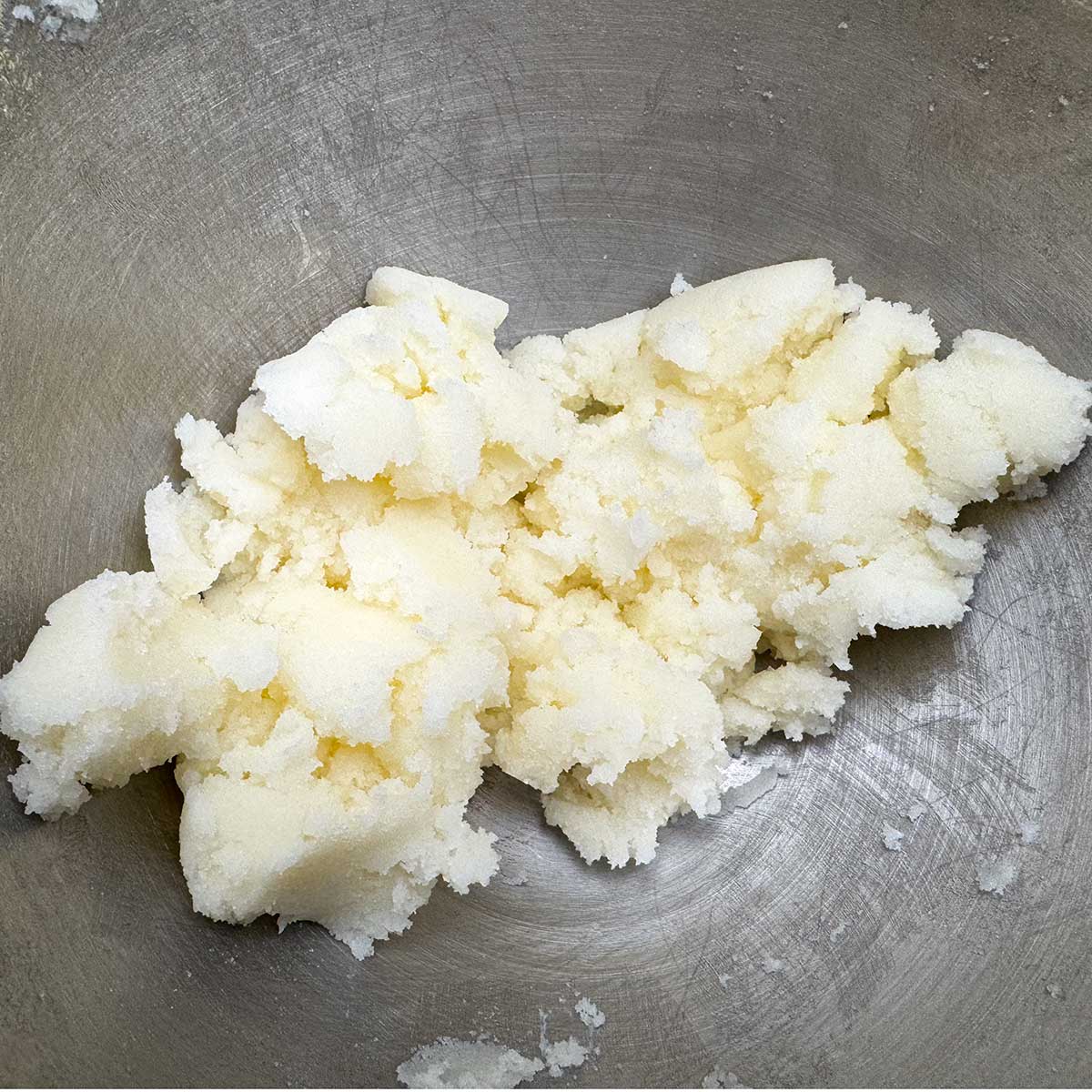 Butter and sugar mixed in a mixing bowl.