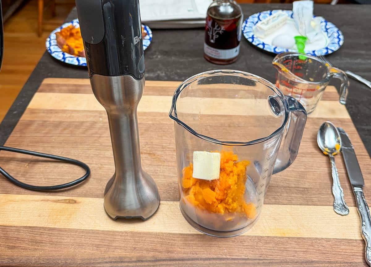 Using a stick blender to puree the sweet potatoes.