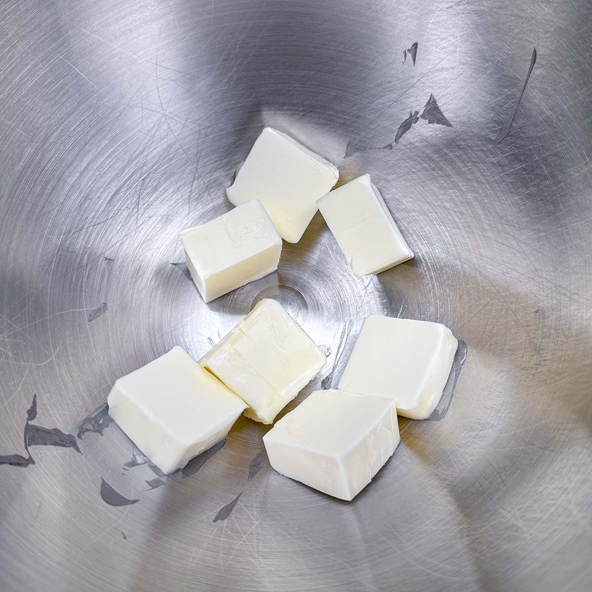 Cubed butter in a mixing bowl, ready to be creamed.