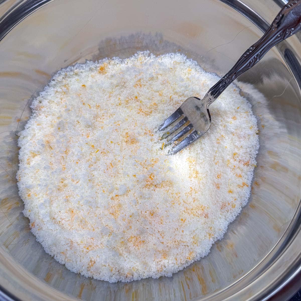 Mixing the sugar and the orange zest to be added and mixed into the creamed butter.