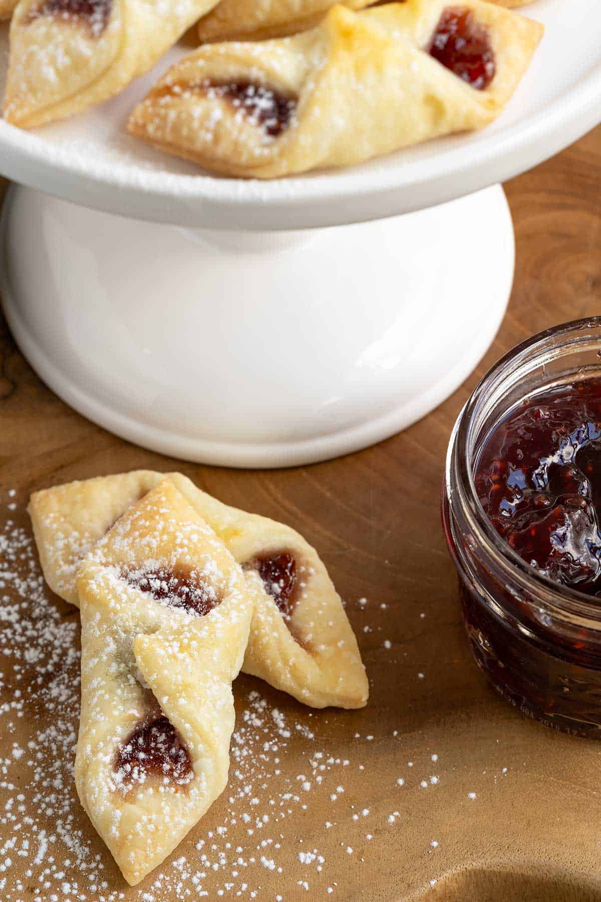 Red raspberry kolache cookies that have been dusted with powdered sugar.