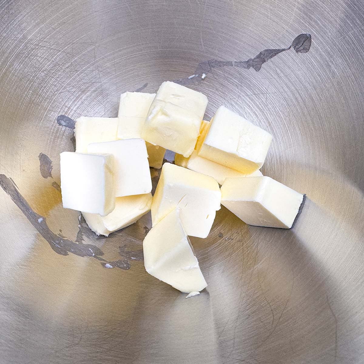 Butter that has been cubed and sitting in a mixer bowl.