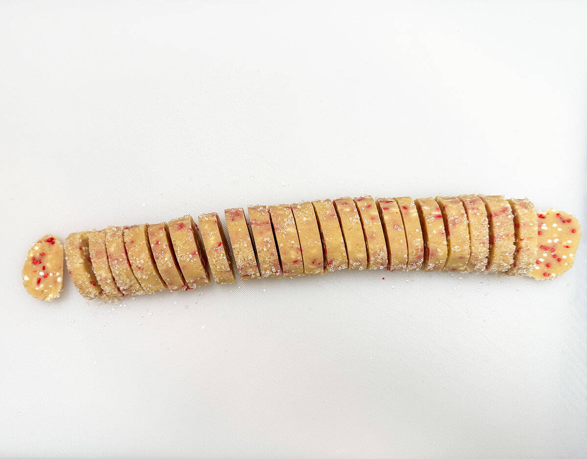 Slicing the 9 inch cookie log into quarter inch slices.