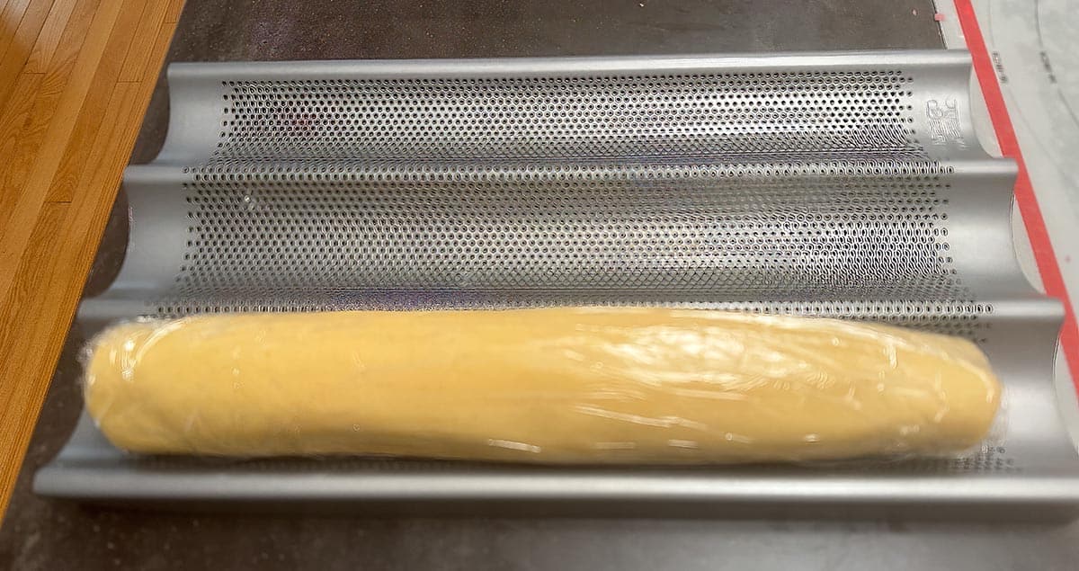The pinwheel roll of cookie dough wrapped in plastic wrap.