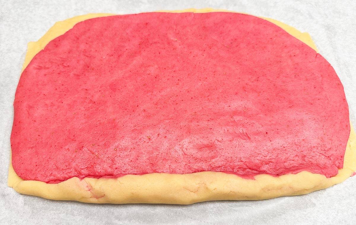 Rolling the strawberry and the vanilla cookie together so it can be chilled.