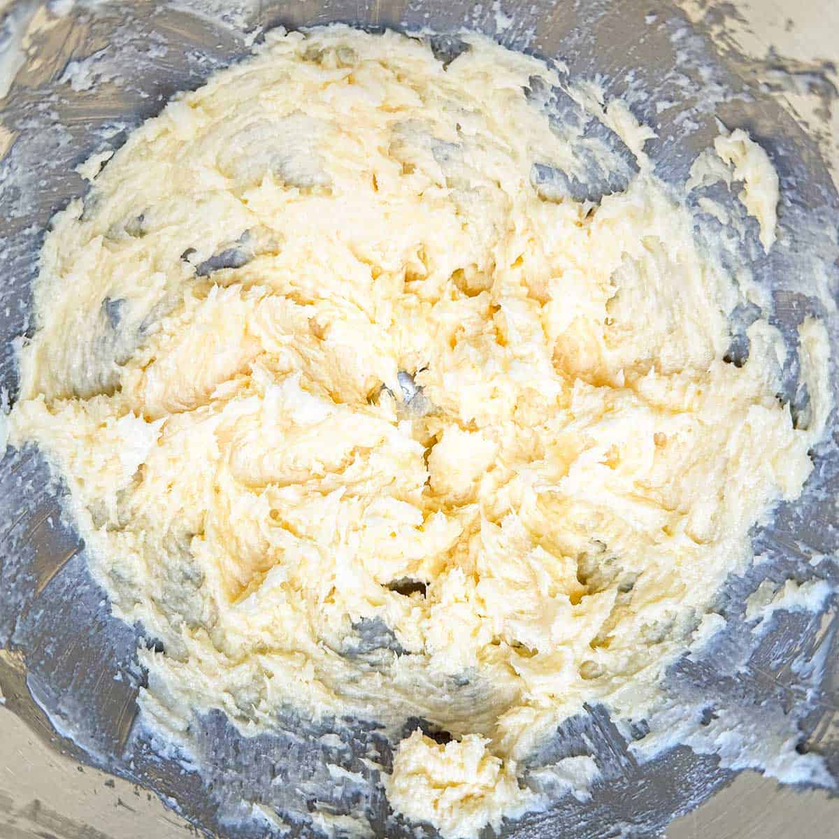 Adding the vanilla extract and the egg to the butter-sugar mixture.