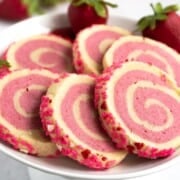 Strawberry and vanilla pinwheel sugar cookies from view of the nice pinwheel of the two color cookie dough and the jimmies on the side.