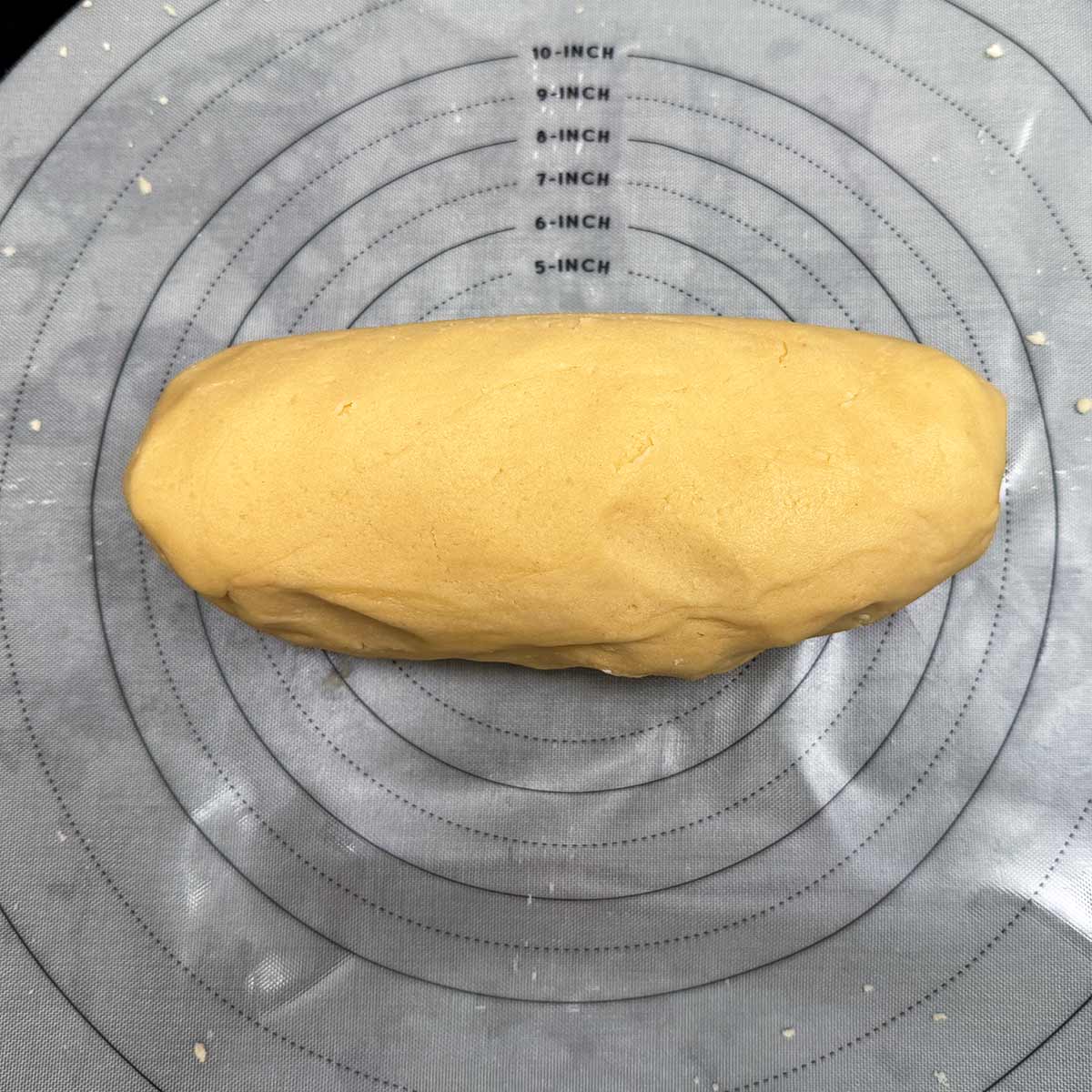 Cookie dough that has been kneaded to absorb flour bits molded into a tube shape.