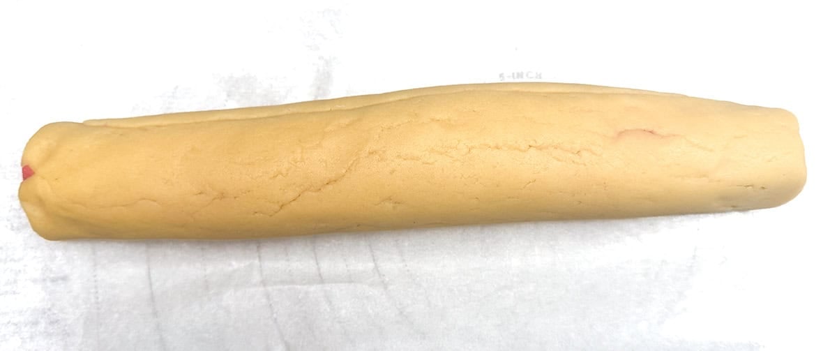 Both vanilla and strawberry cookie dough has been rolled together and fixing any tears in the vanilla outside dough.