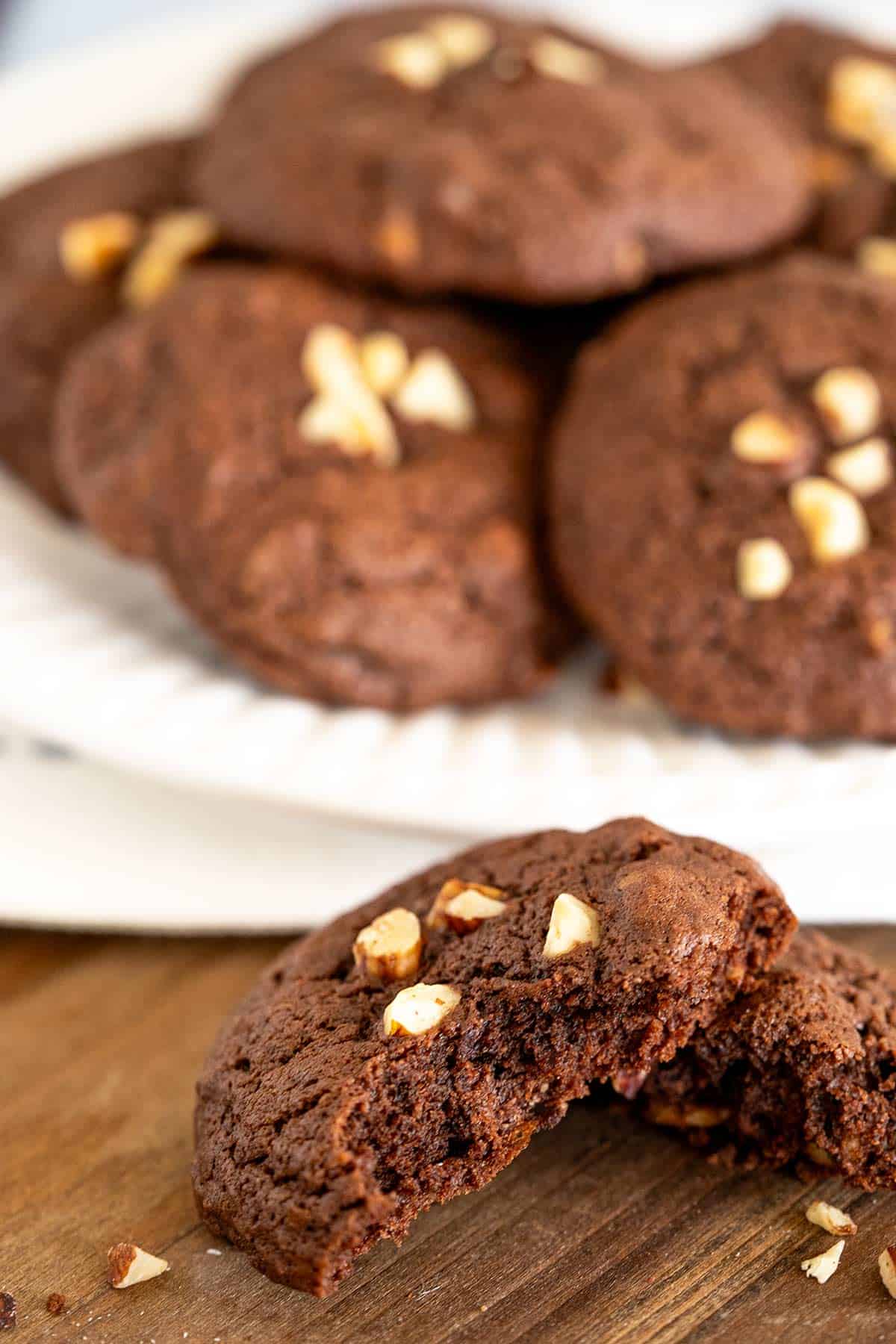 Chocolate orange hazelnut cookies broken in half to show rich chocolate cookie.