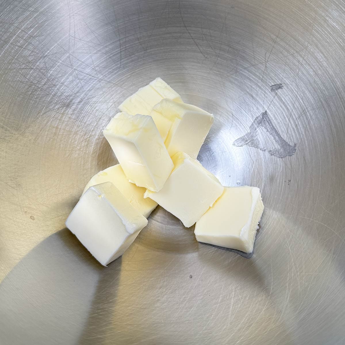 Cubed butter in a mixer bowl.