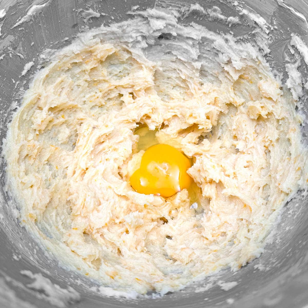 Adding an egg to the cookie dough.