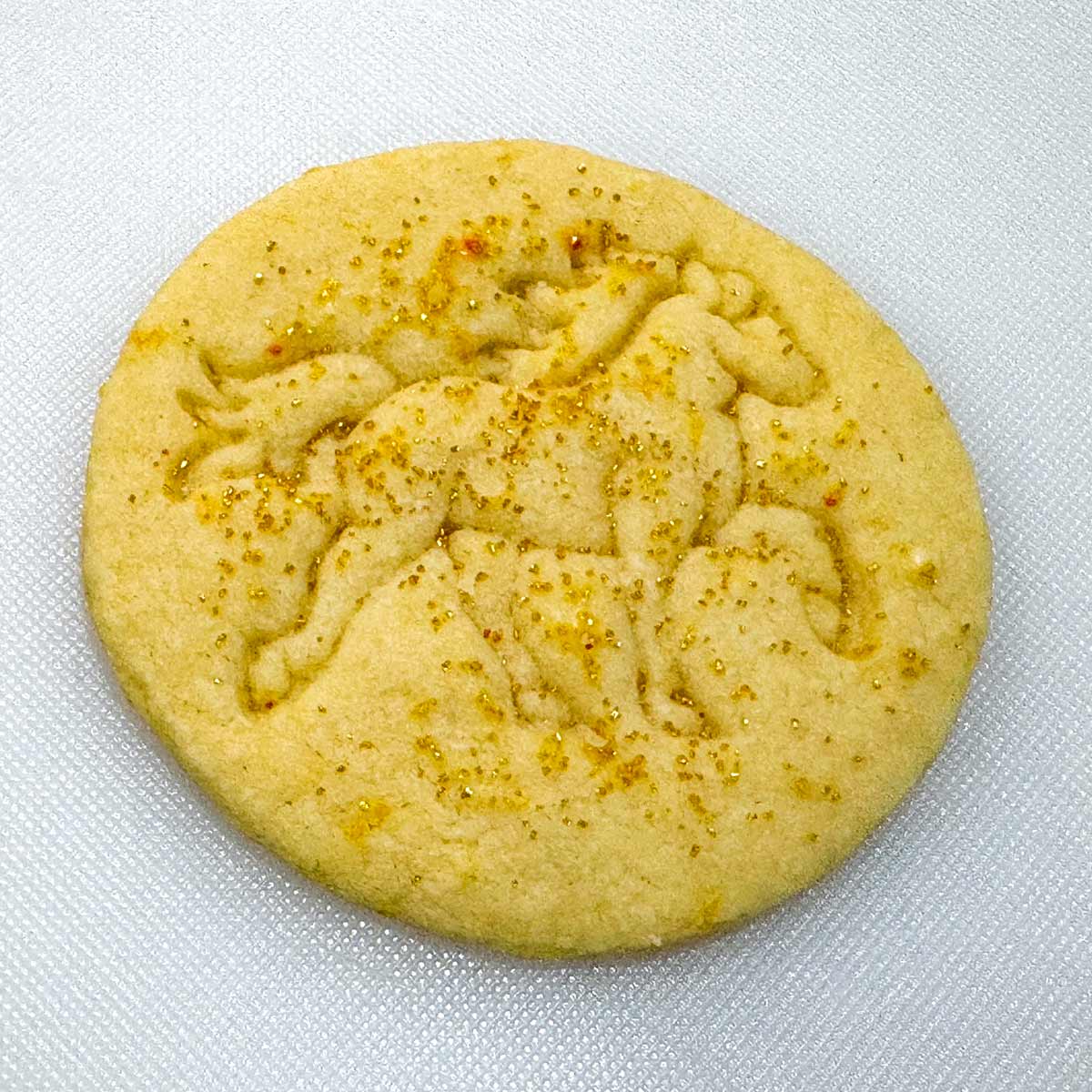 Adding the thin glaze and sprinkling gold colored sugar on the top.