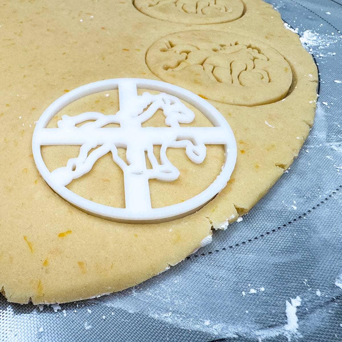 Using the horse cookie cutter on the rolled out cookie dough.