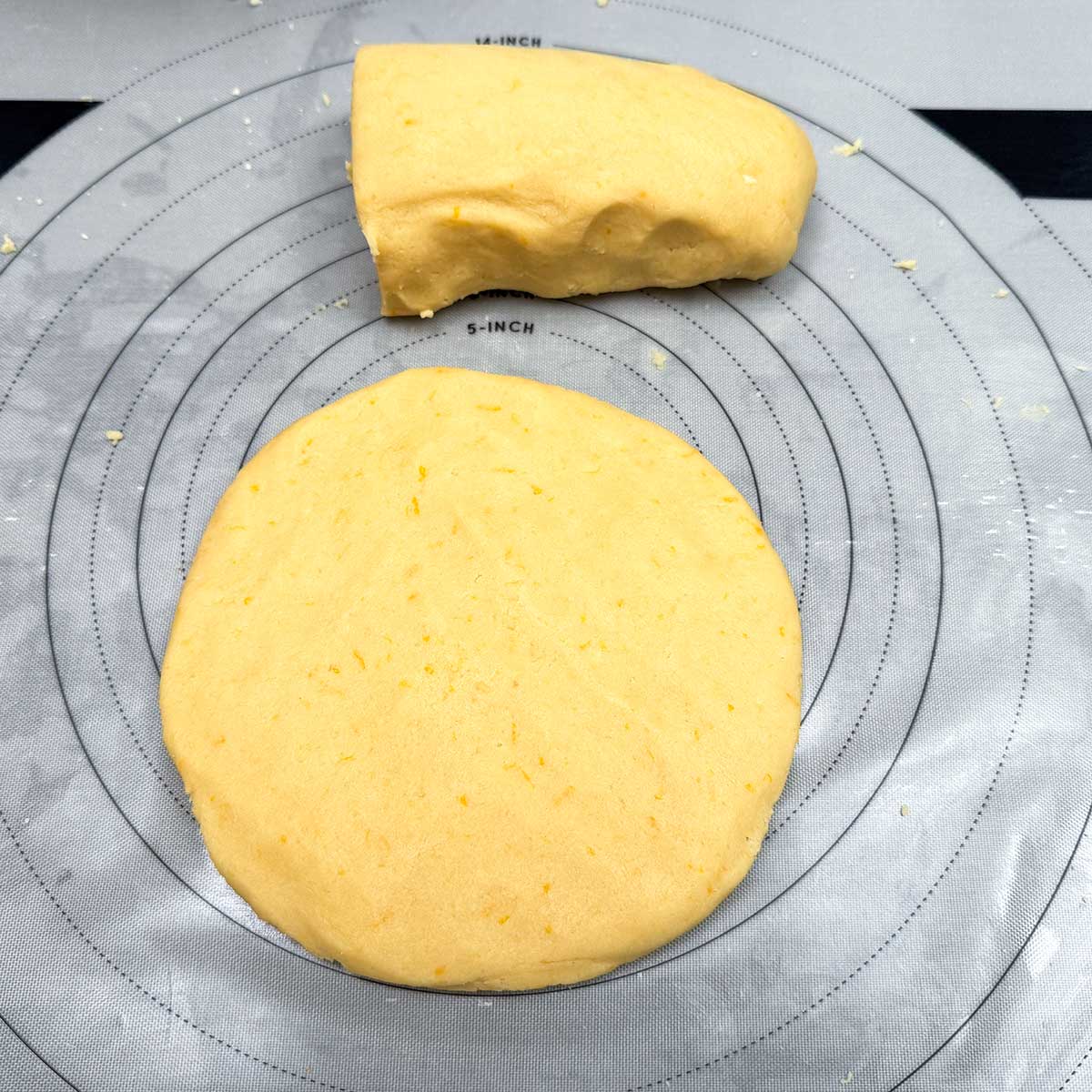 Splitting the kneaded log into two so it can be flattened into disk shapes.