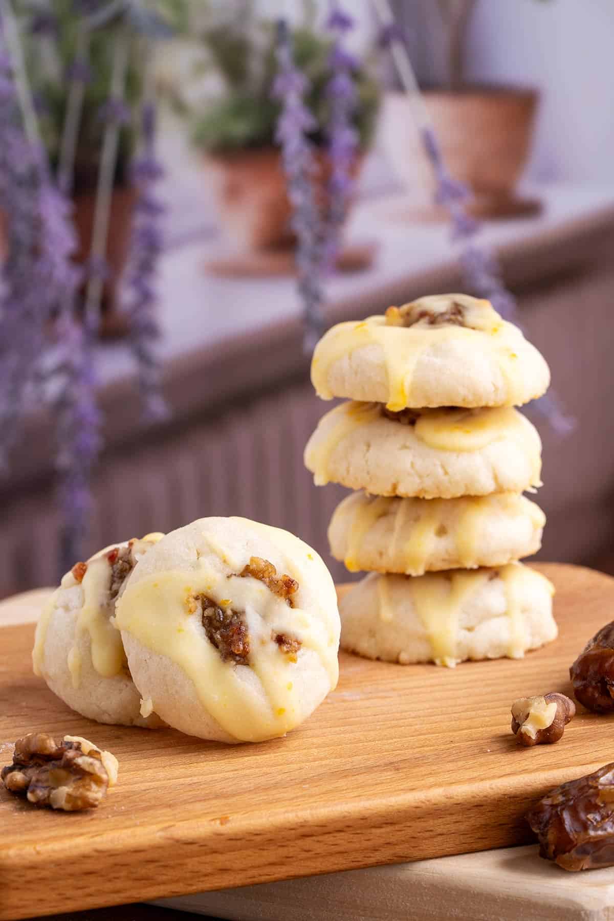 Honey orange glazed walnut date cookies on a board with a stack of cookies and a single front view of one cookie.