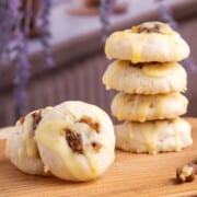 Honey orange glazed walnut date cookies on a board with a stack of cookies and a close up of one cookies.