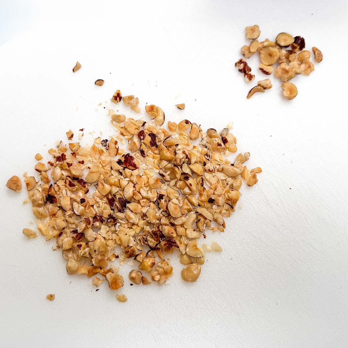 Chopping hazelnuts into small pieces about the same size as the cinnamon chips.