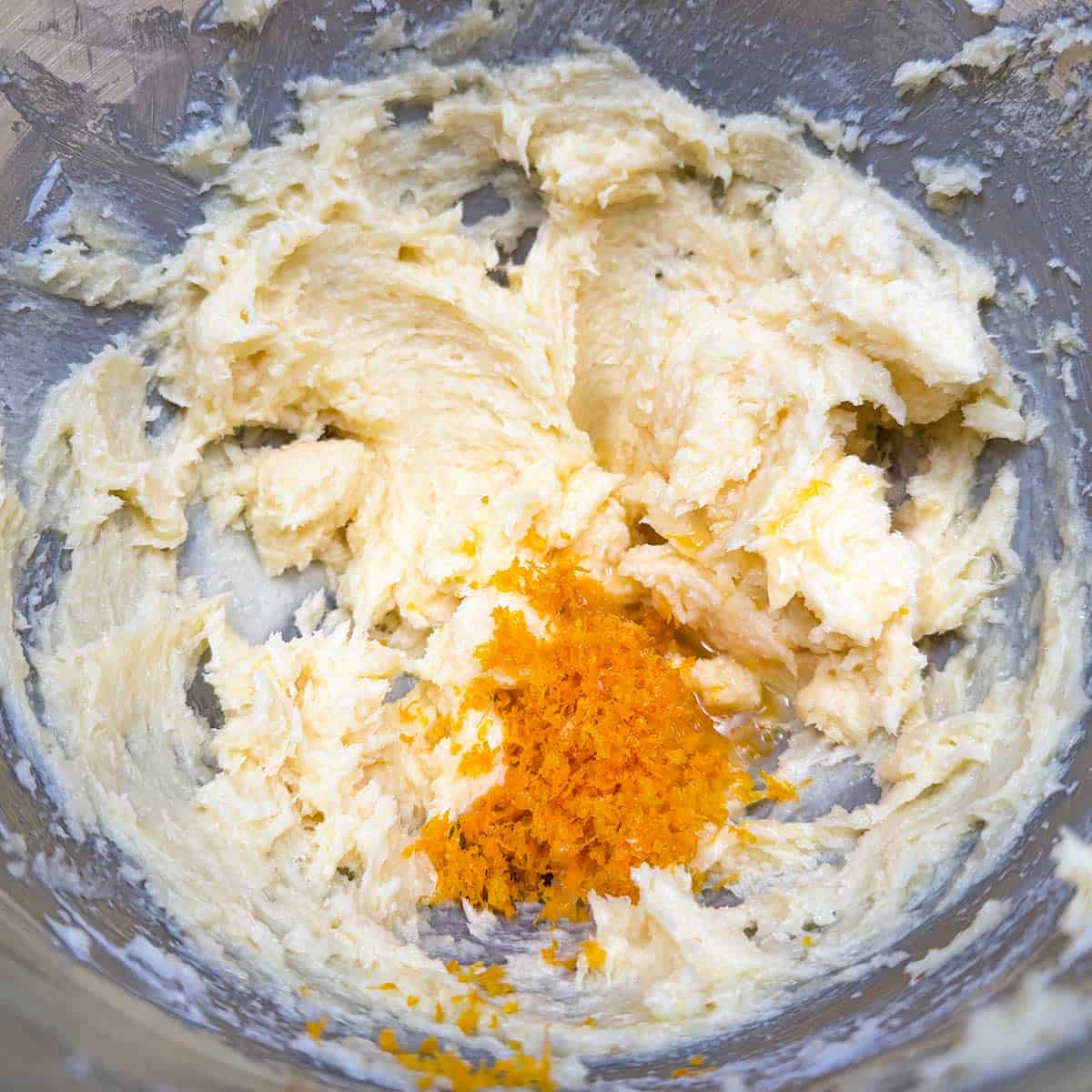 Adding the orange zest and juice to the wet cookie dough.