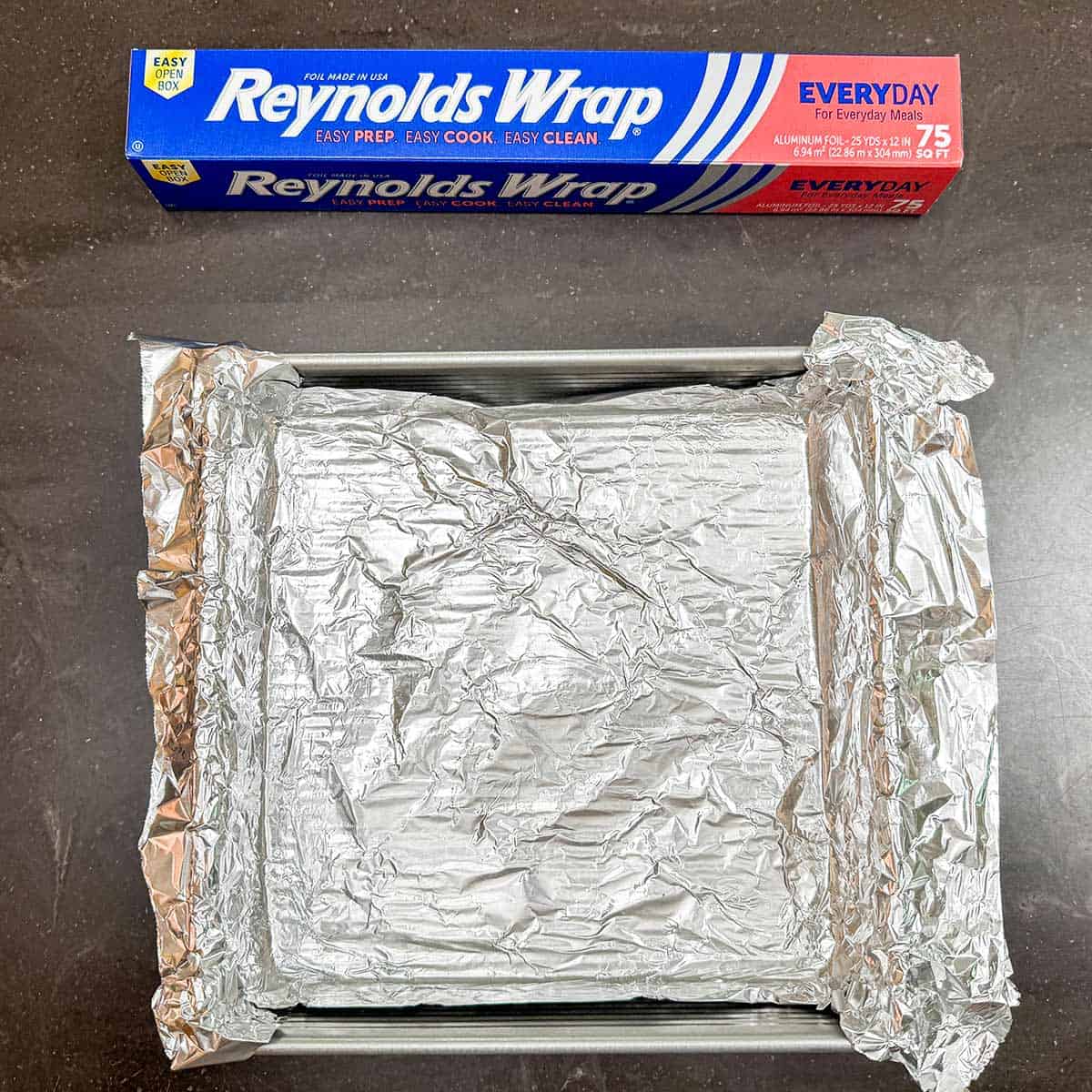 Pan lined with tin foil that has an overhang on opposite sides for handles to pull the cheesecake out when chilled.