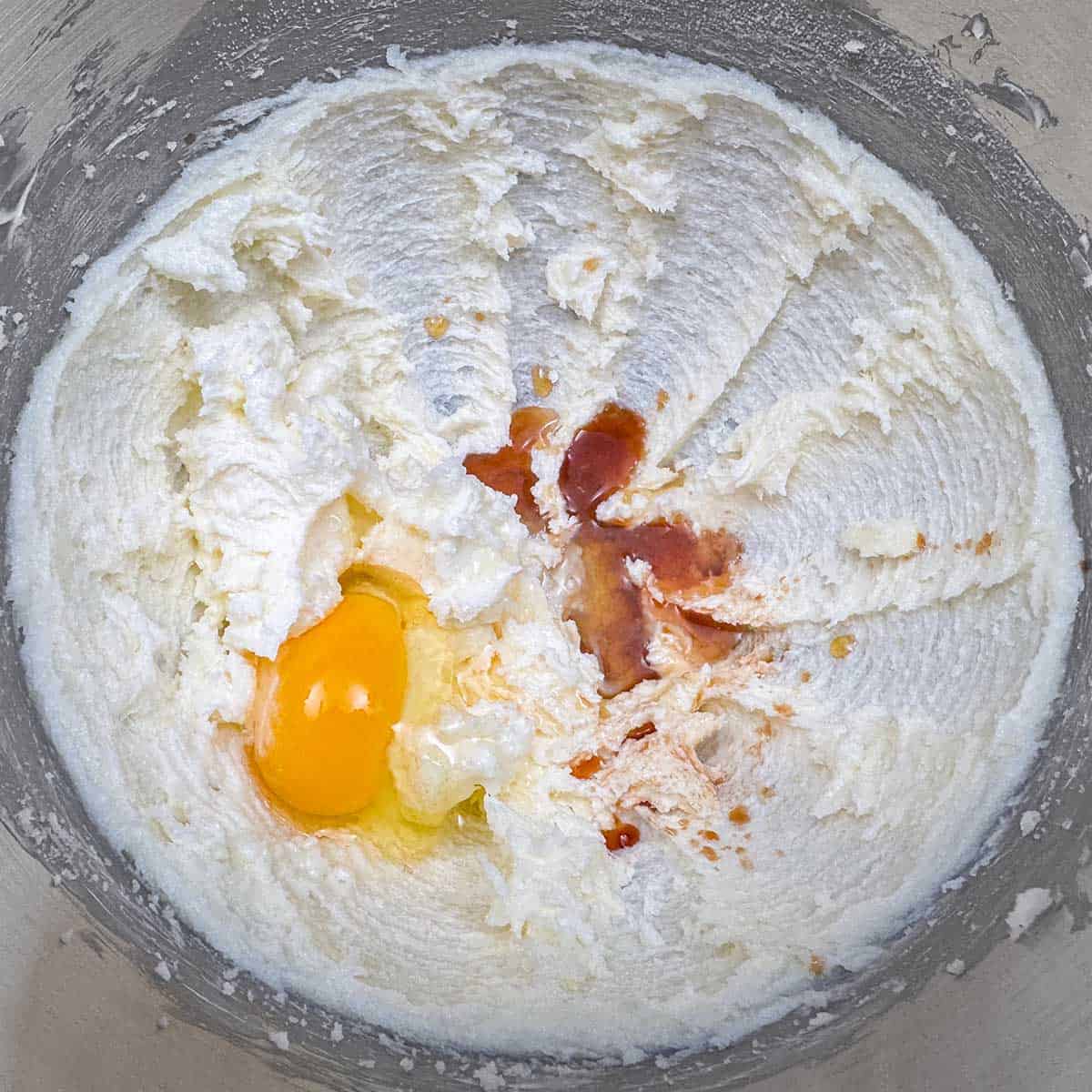 Adding egg, vanilla extract, maple syrup and lemon juice to the butter sugar mixture.