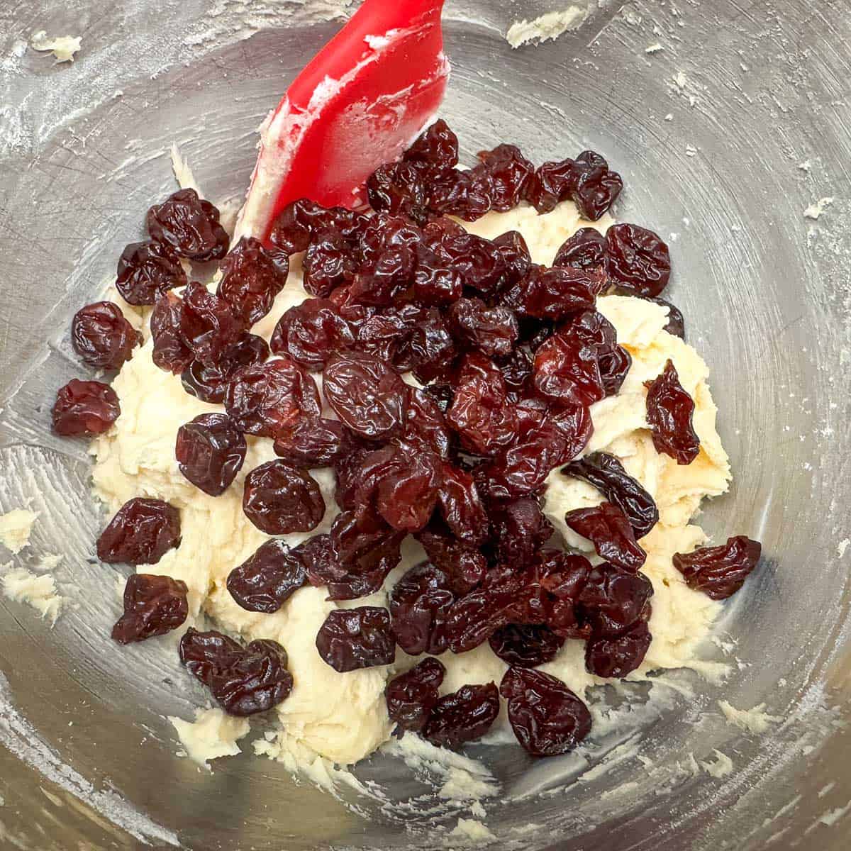 In the mixer bowl adding the cherries to the cookie dough.