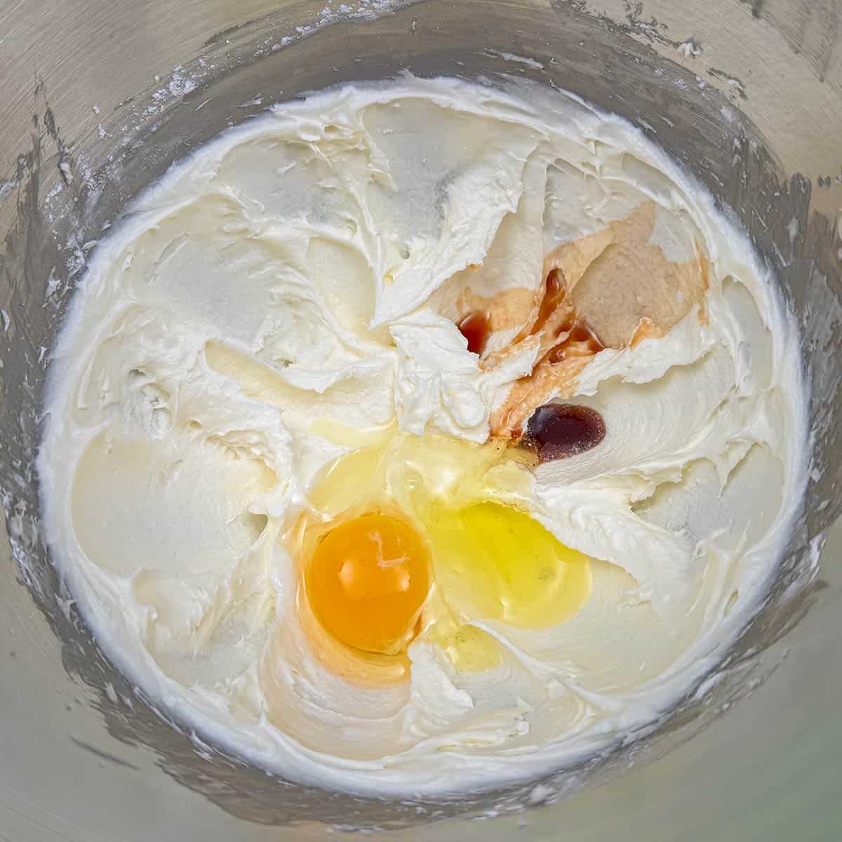 Adding egg and vanilla extract to the butter sugar mixture.