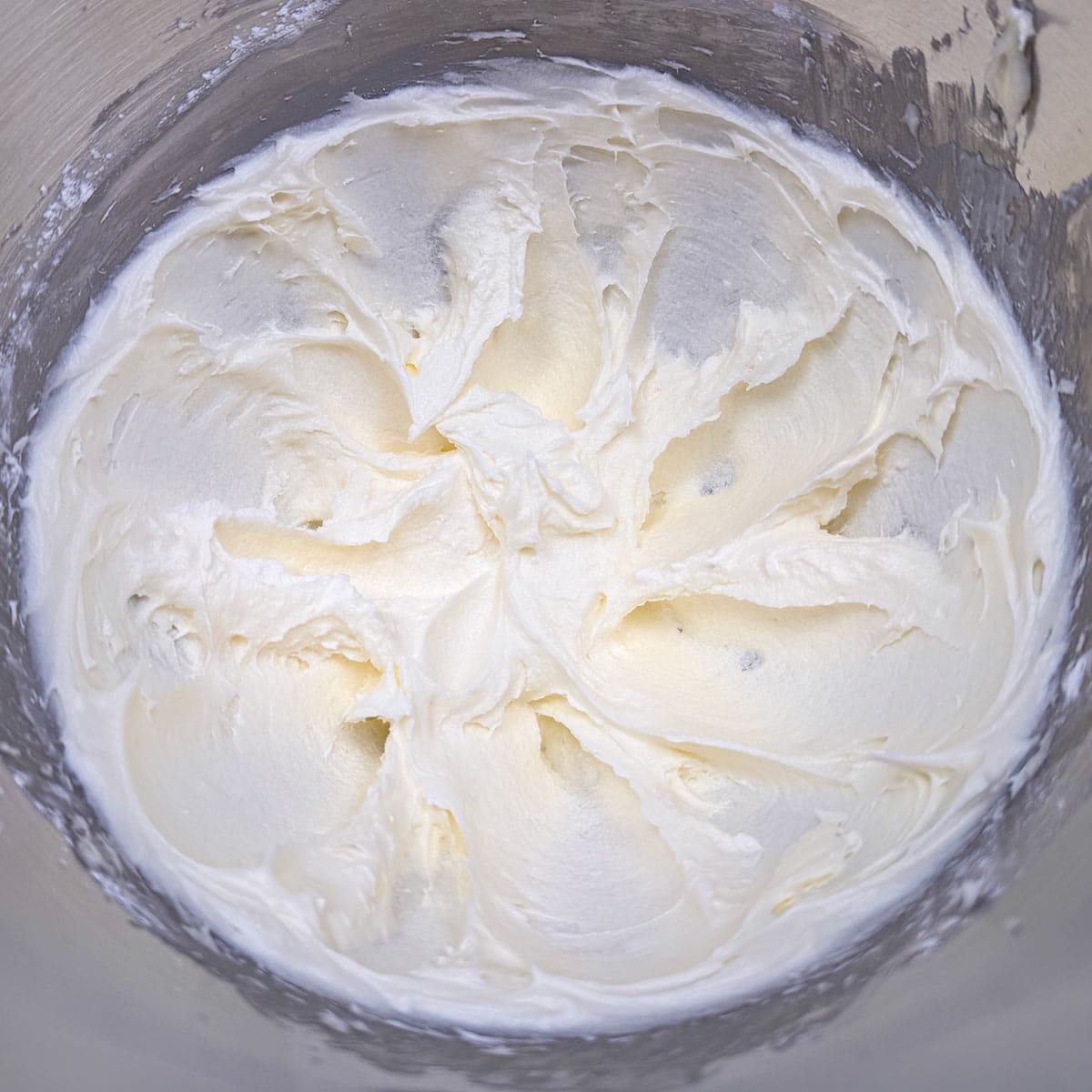Powdered sugar has been mixed into the butter mixture and looks smooth like icing.