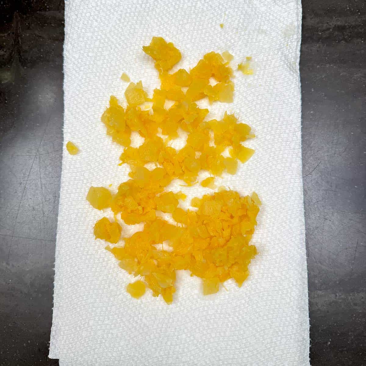 Drained pineapple laying on paper towels.