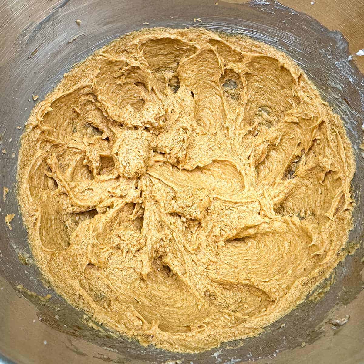 All the wet ingredients for the chewy ginger molasses cookies is mixed in a mixer bowl.