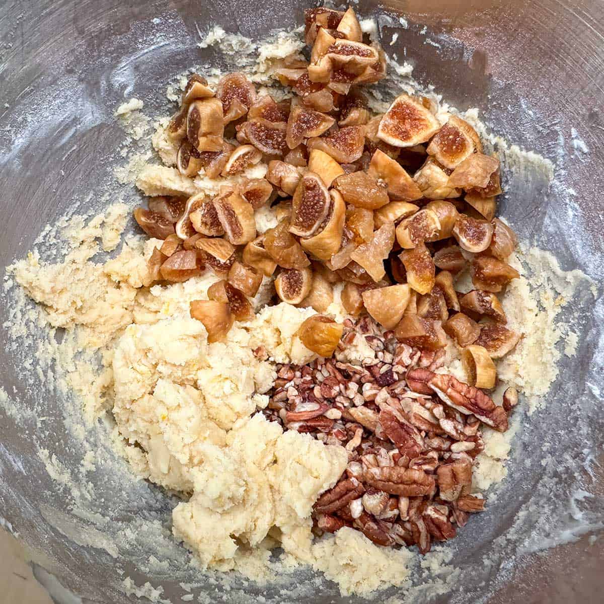 Adding the pecans and the cut up figs to the cookie dough.