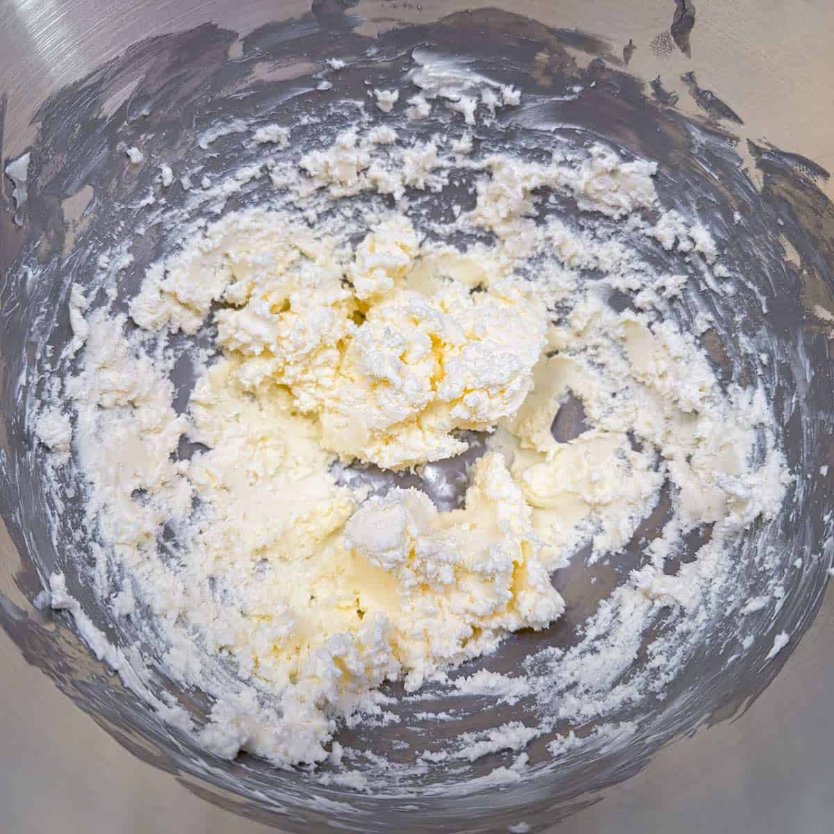 Butter and cream cheese mixed, looking lumpy.