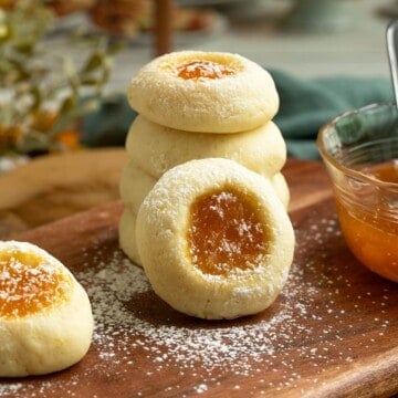 Apricot Cream Cheese Cookies stacked with powdered sugar sprinkled on top.