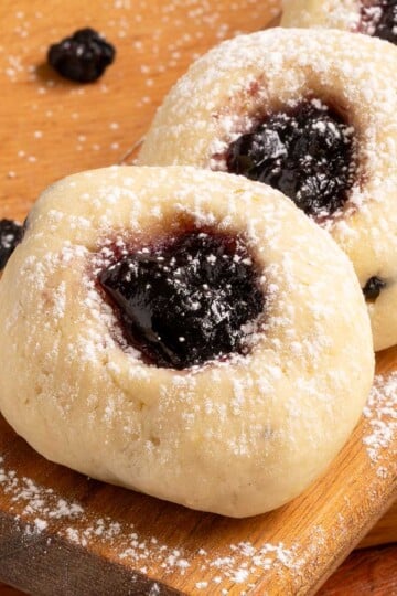 Blueberry cream cheese thumbprint cookies close-up on a cutting board.