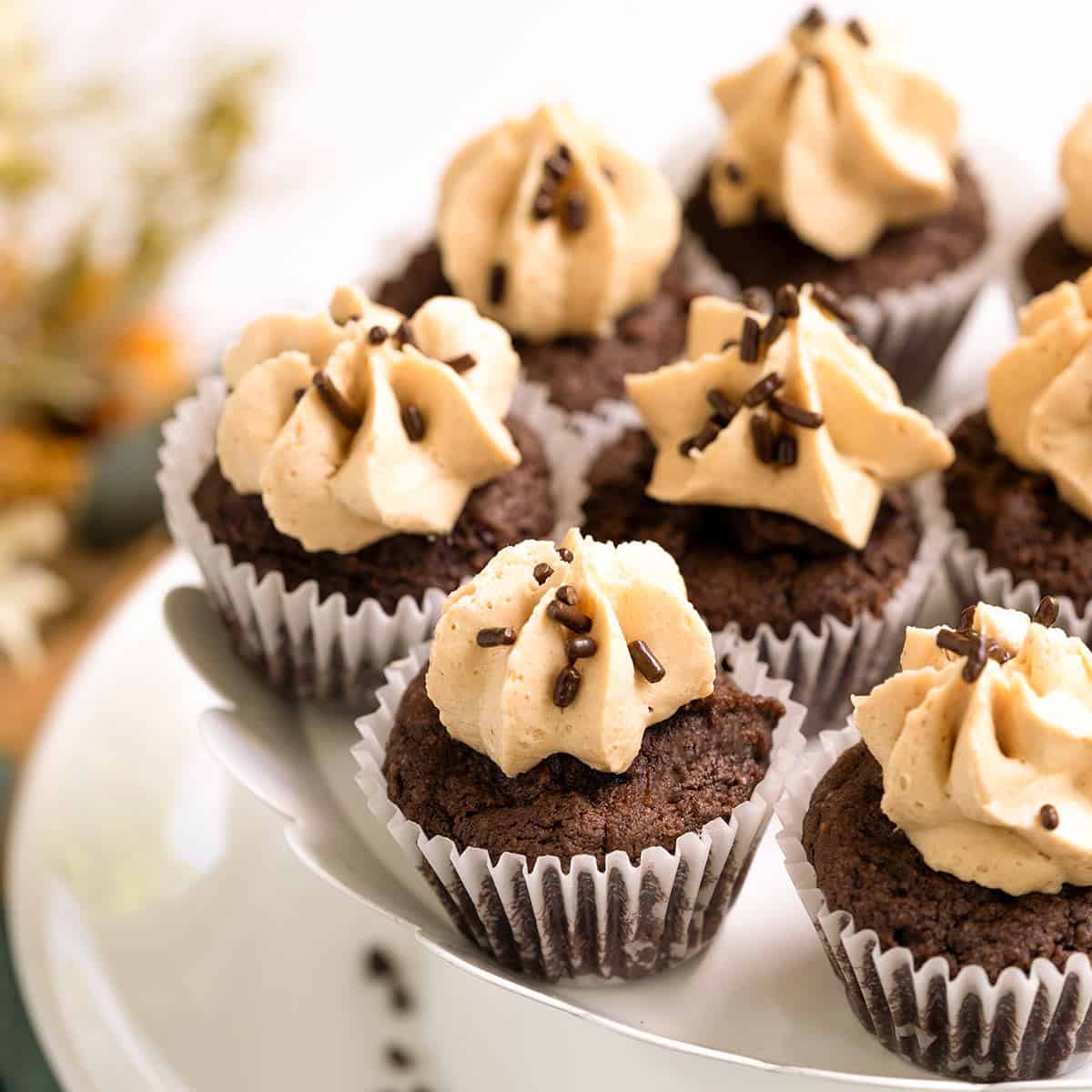 Close up of Chocolate cookie cupcakes with peanut butter frosting sitting on a plate.