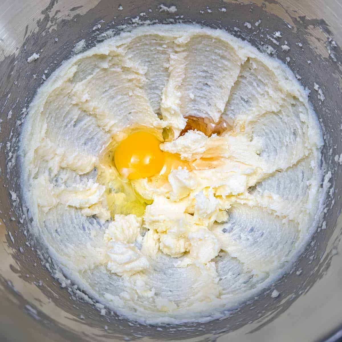 The egg, almond extract and honey are added to the butter-sugar mixture in a mixer bowl.