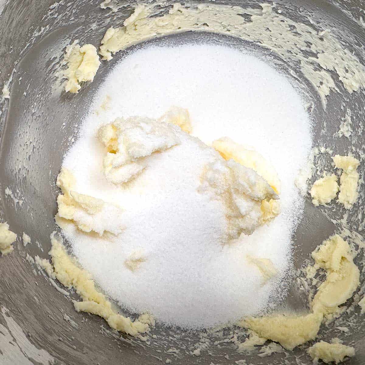 Adding sugar to the creamed butter.